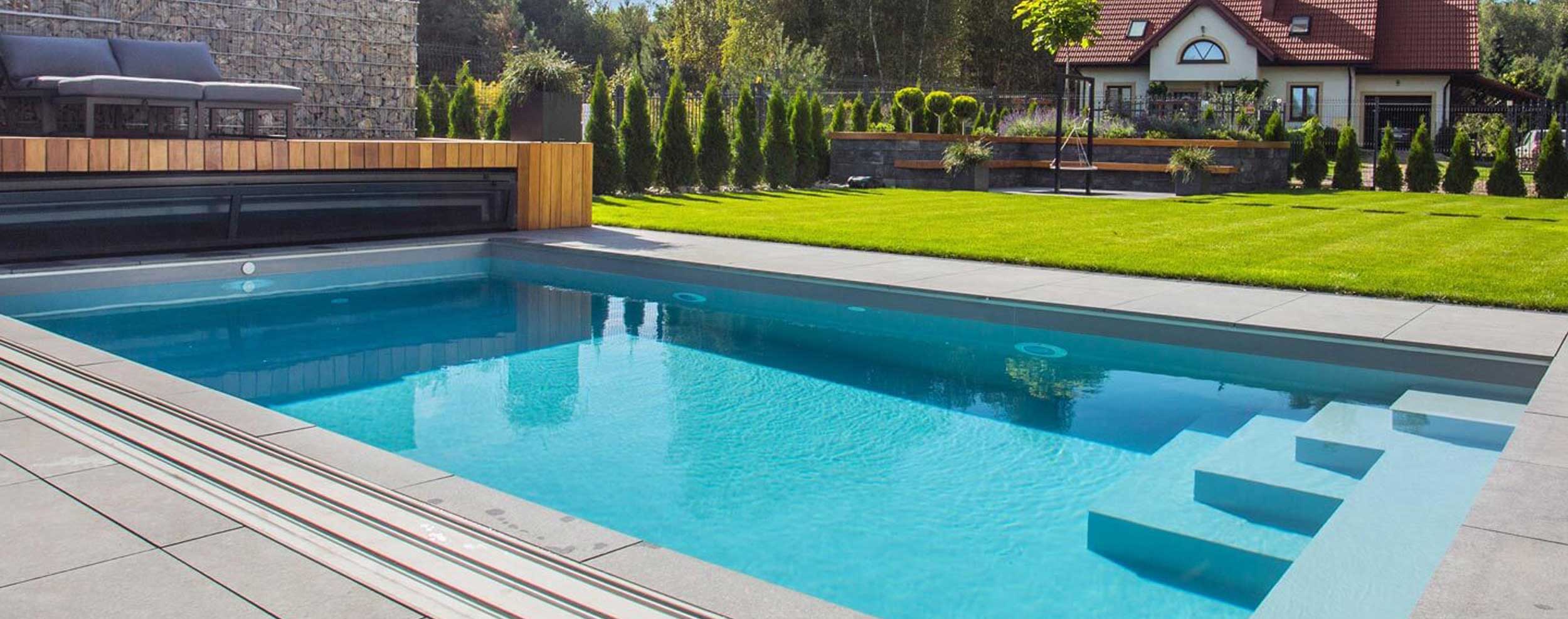 Pool eingebettet in einen herrlichen Garten mit geöffneter Überdachung bei Sonnenschein